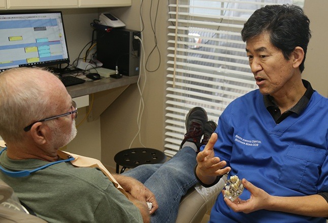 Doctor song talking to dental patient