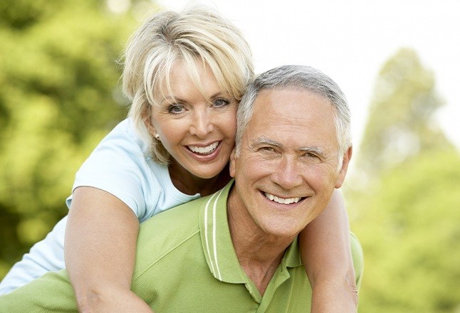 Older man and woman with dentures on golf course