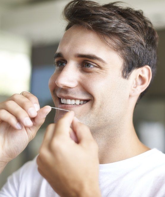 Man flossing teeth to prevent dental emergencies