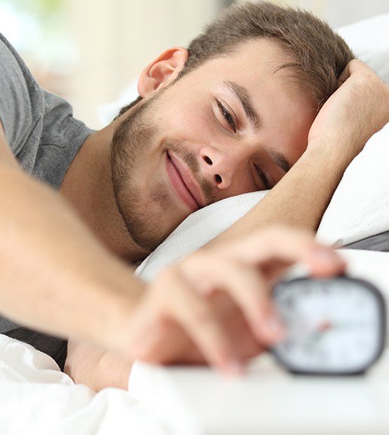 Man waking up feeling refreshed thanks to sleep apnea treatment
