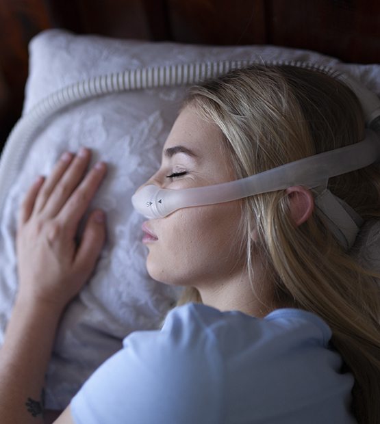 Woman using combined sleep apnea oral appliance and C pap treatment