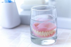 Dentures soaking in a glass of water