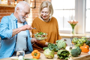 A cheerful senior couple eating a salad together