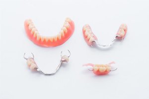 Full denture and various partial dentures on white background