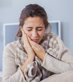 Woman with toothache holding jaw