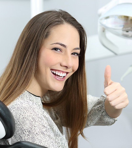 Woman giving a thumbs up at the dentist’s office