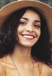 Young woman in sunhat smiling outdoors