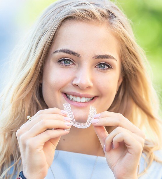 Young woman placing an clear aligner tray