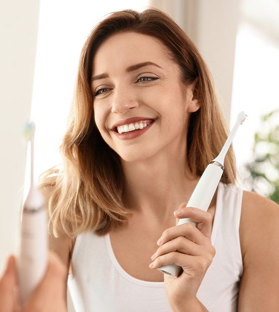 Woman using electric toothbrush